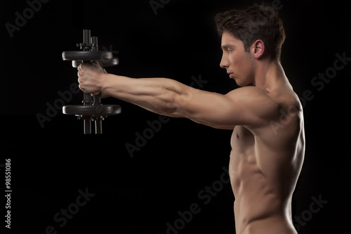 muscular young man with weights on a black background