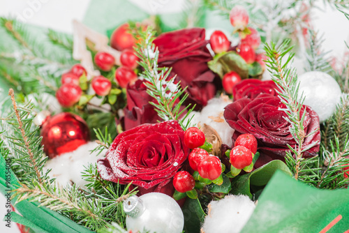 Fototapeta Naklejka Na Ścianę i Meble -  Close-up of Christmas bouquet with flowers and spruce with snow.