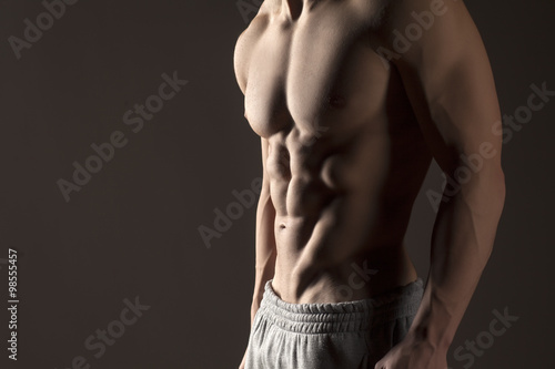Muscular male torso on a gray background