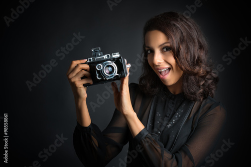 Brunette woman holding a vintage camera