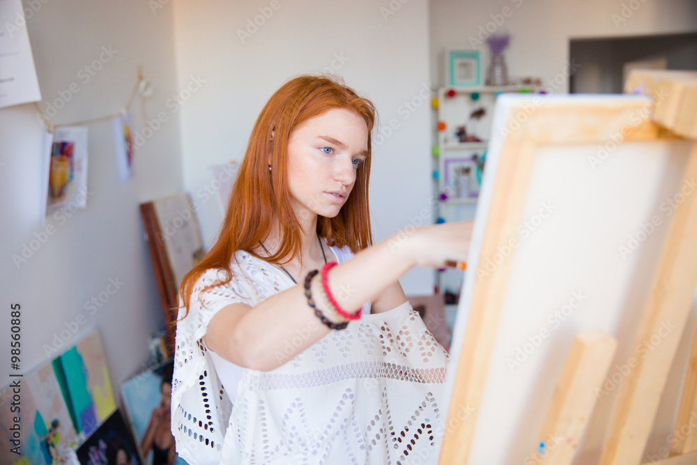 Beautiful pensive young woman painter working in art studio Beautiful pensive young woman painter working in art studio