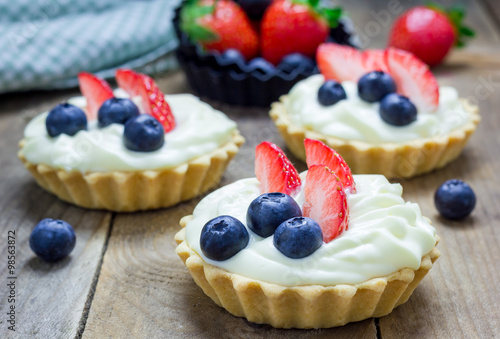 Fotografiet Homemade shortbread tartlets with custard cream, strawberry and blueberry