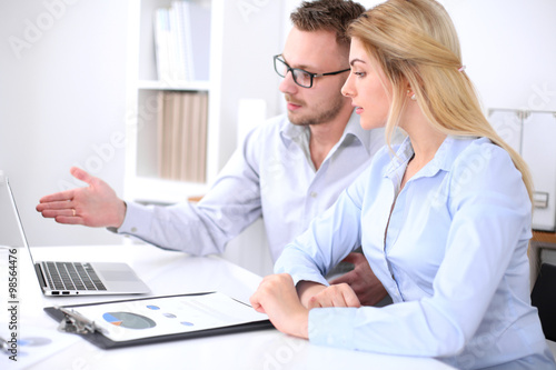 Two successful business partners working at meeting in office