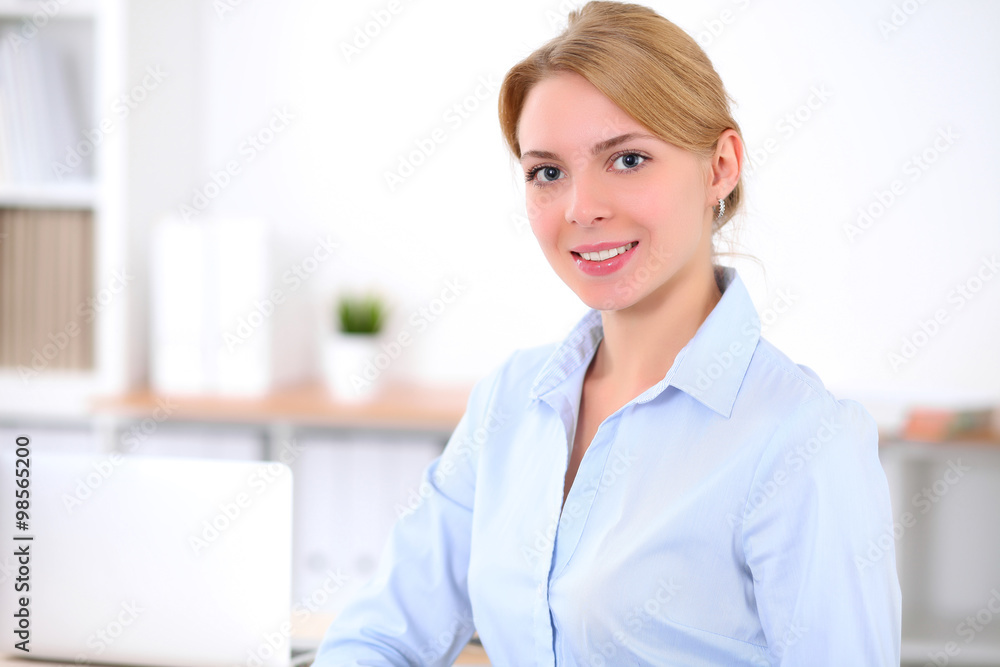 Young blonde business woman with laptop in the office. Business concept.