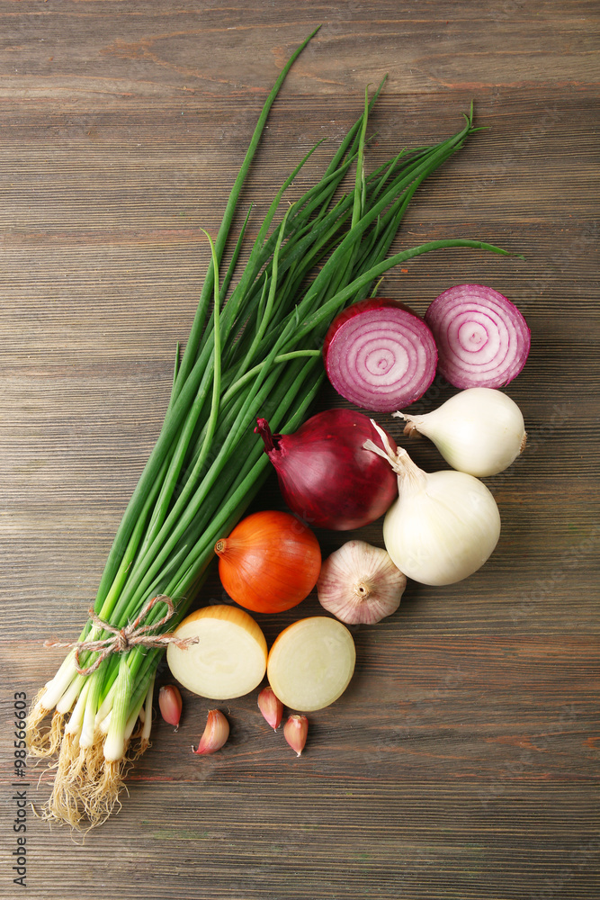 Fresh different onions with garlic on wooden background Fresh different onions with garlic on wooden background