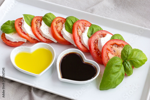 Tomato slices, basil and goat cheese with oil and vinegar