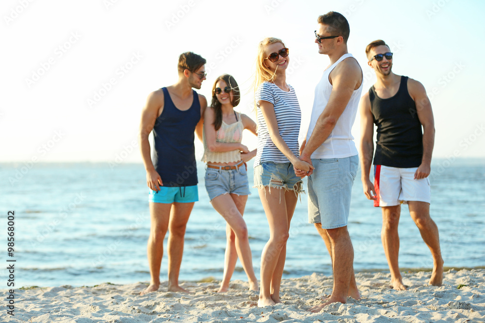 Happy couple and friends having fun at the beach, outdoors Happy couple and friends having fun at the beach, outdoors