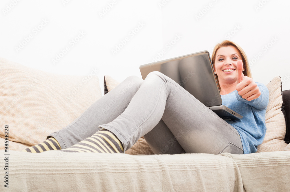 Woman with laptop on the couch showing like Woman with laptop on the couch showing like