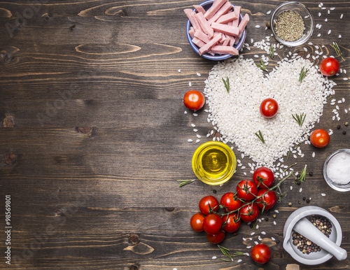 Healthy foods, cooking and concept risotto with ham, oil, cherry tomatoes, rice tiled heart, valentines day border ,place for text on wooden rustic background top view close up