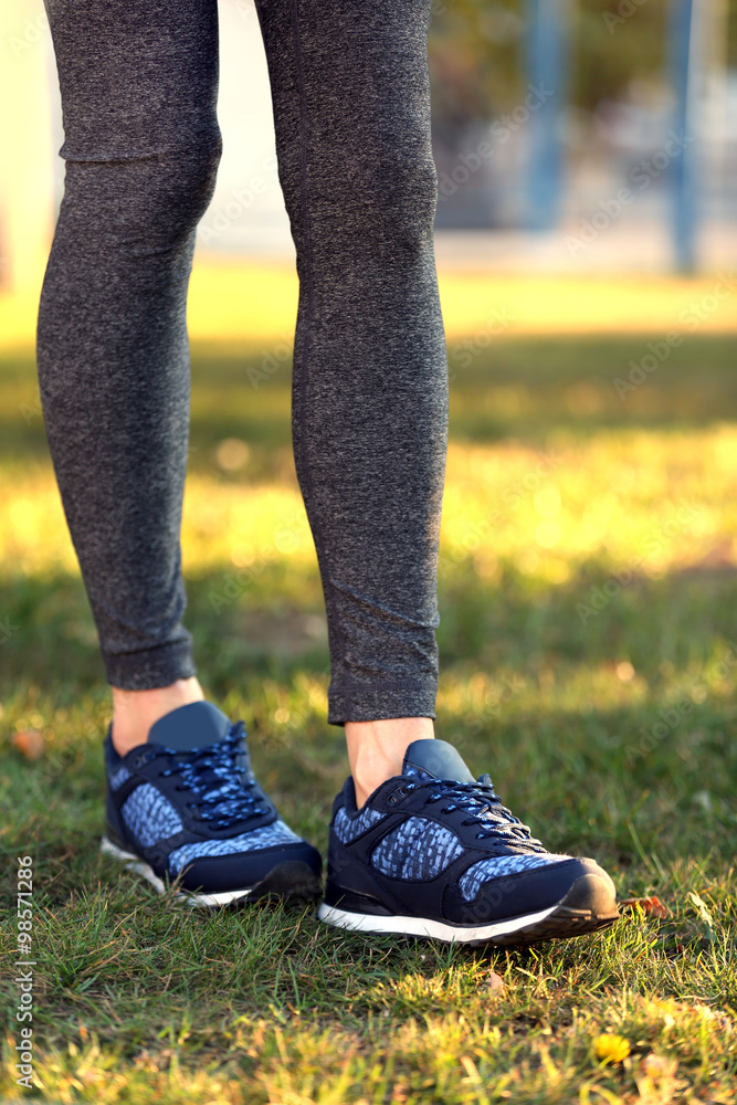 Sports woman legs in sneakers outdoor