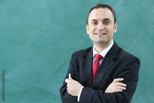 The Male Teacher in the classroom. Turkish teacher have chalk in his hand.