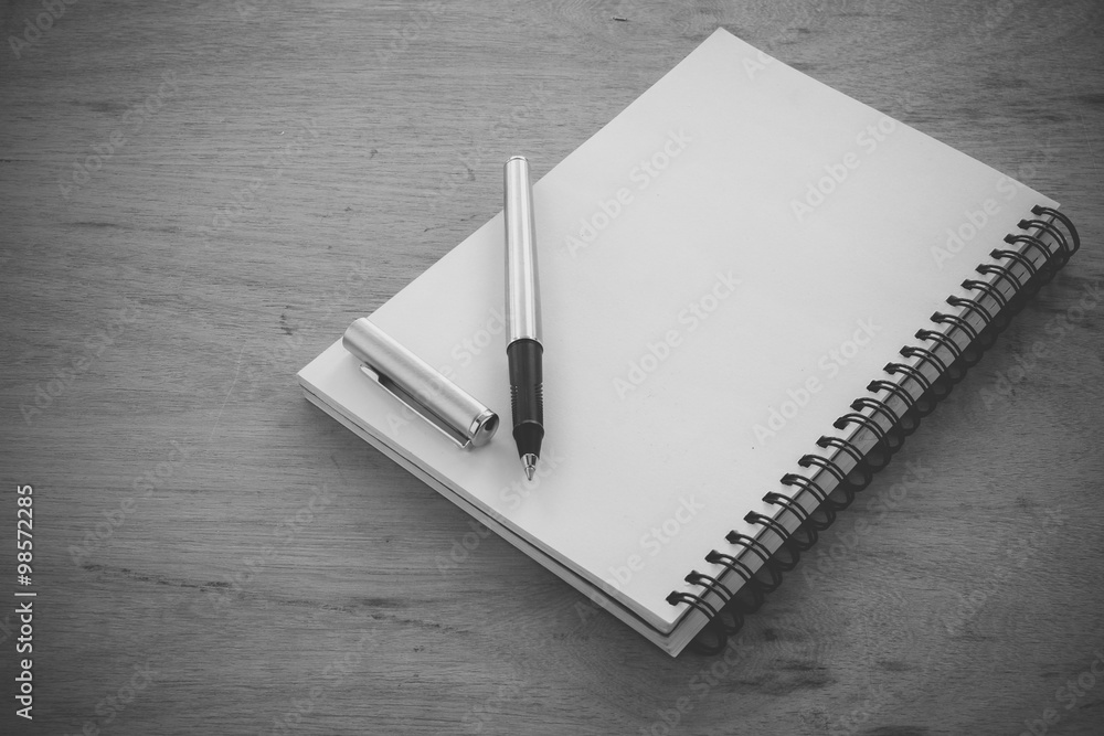 paper notebook and pen on a table with filter effect retro vinta