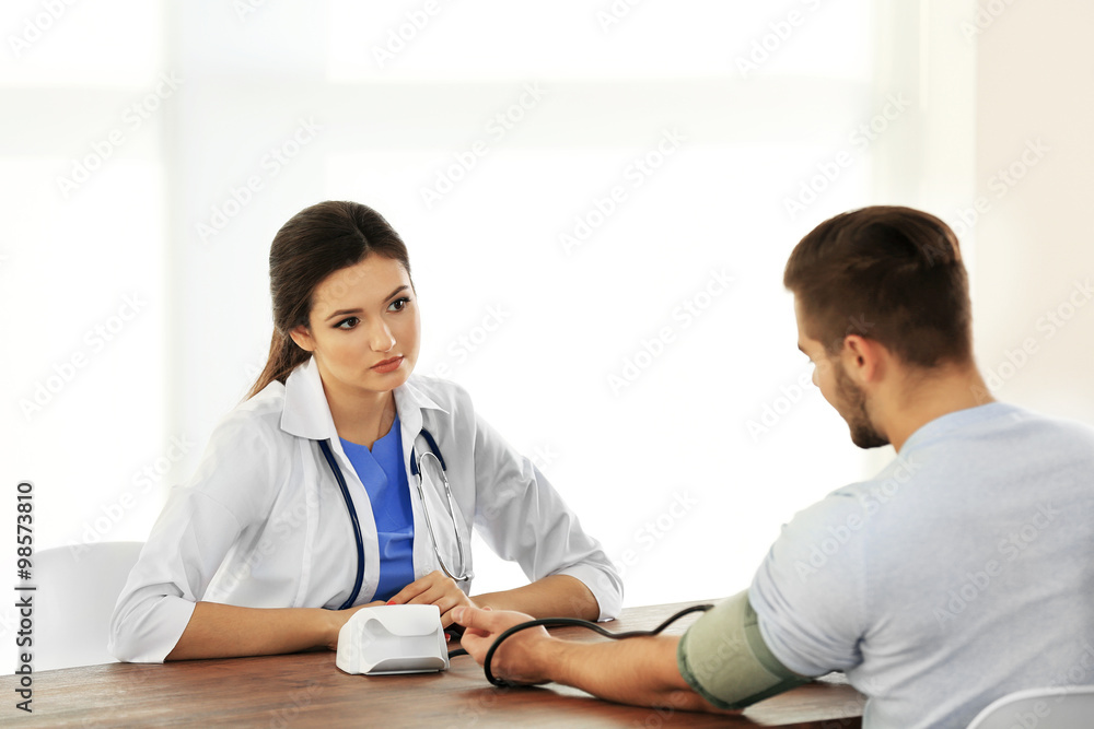 Female doctor examining patient blood pressure Female doctor examining patient blood pressure