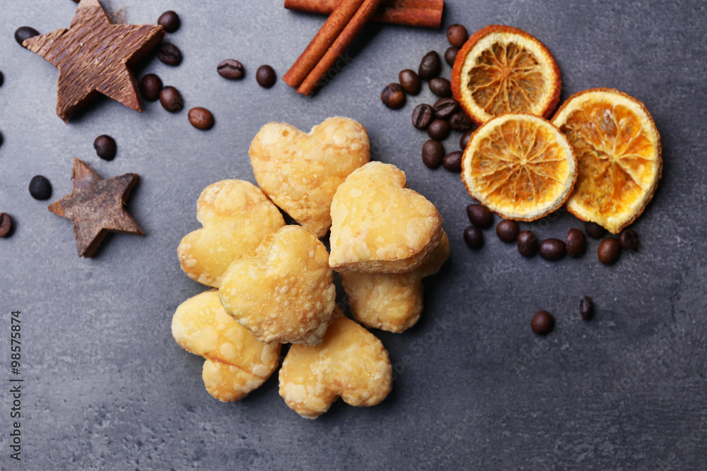 Fototapeta premium Heart shaped biscuits with dried spices on dark grey background