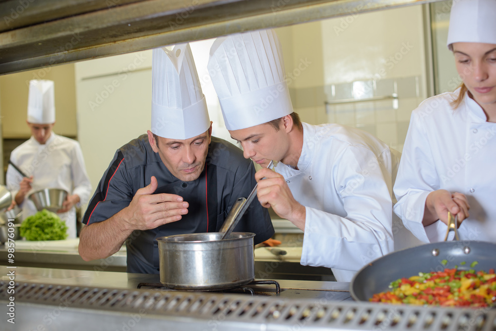 Chef smelling aroma from saucepan Chef smelling aroma from saucepan