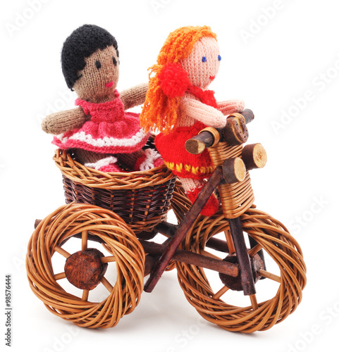 Canvas Print Tied dolls on toy bike.