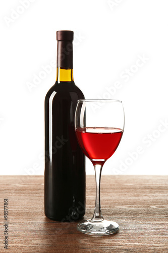 Red wine in bottle and in glass on table isolated on white background