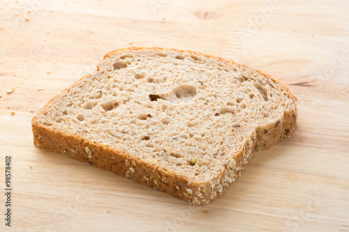 Slice of whole wheat bread on wooden tray