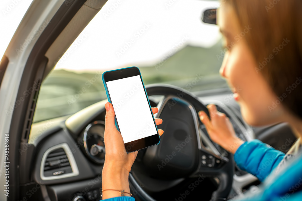 Woman using smartphone driving the car