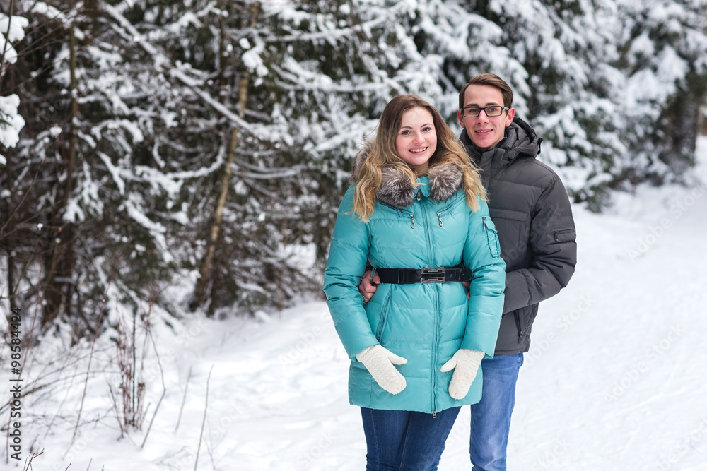 Young beautiful couple walking in winter forest Young beautiful couple walking in winter forest