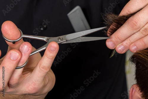 men's hair cutting with scissors in a beauty salon