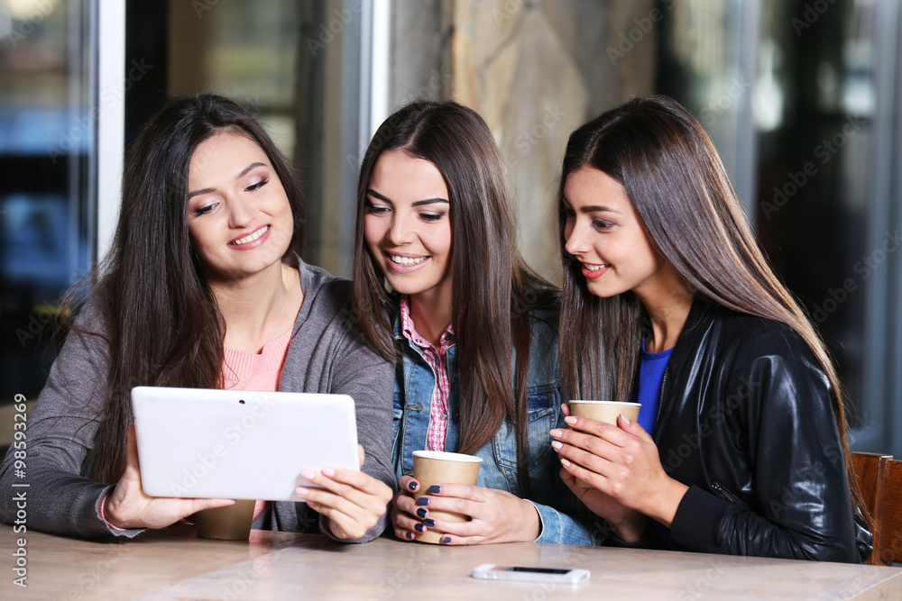 Best friends with tablet together sitting at cafes terrace Best friends with tablet together sitting at cafes terrace