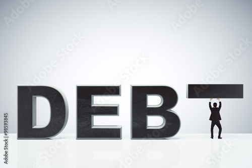 Debt burden concept with debt word and businessman holding inste