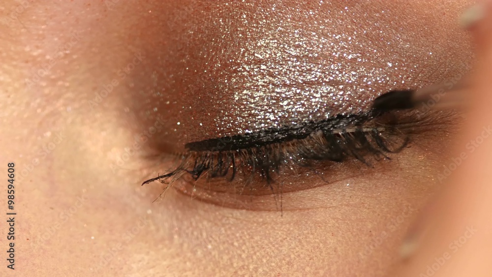 model applying eyeliner closeup on eye, Close up model applying eyeliner closeup on eye, Close up