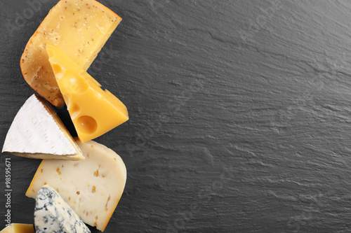 Different kinds of cheese on grey background, copy space