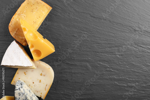 Different kinds of cheese on grey background, copy space photo