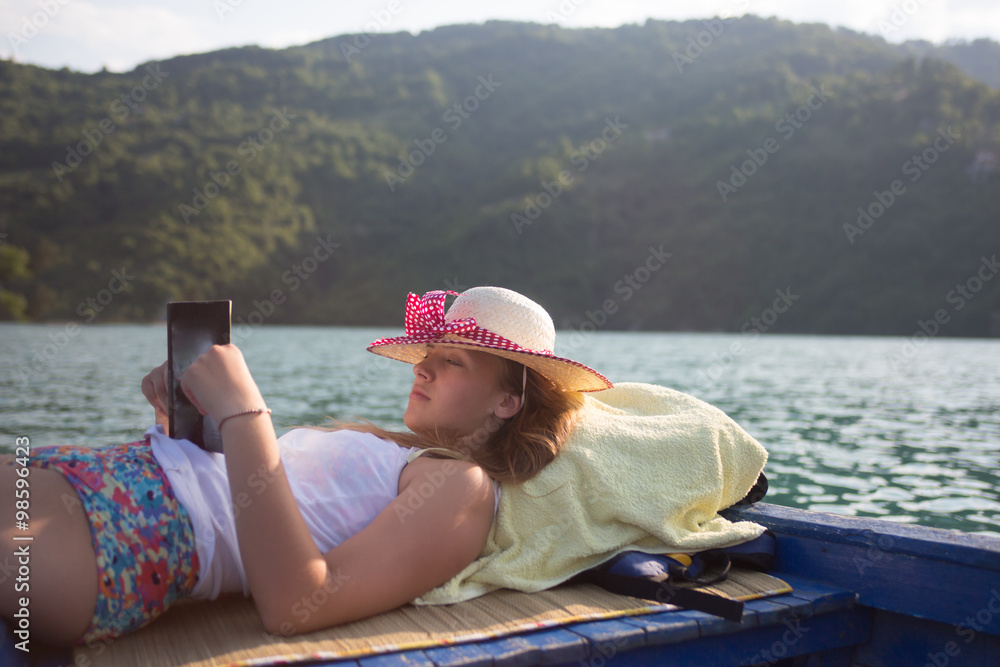 hipster girl reading a book on the boat
