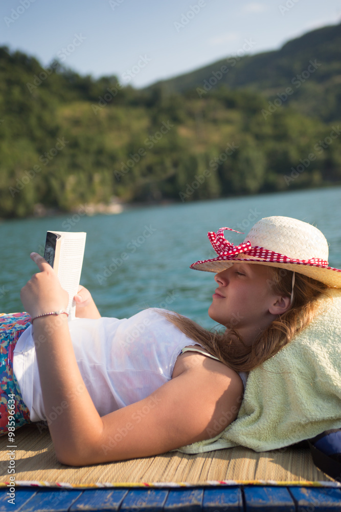 Fototapeta premium hipster girl reading a book on the boat