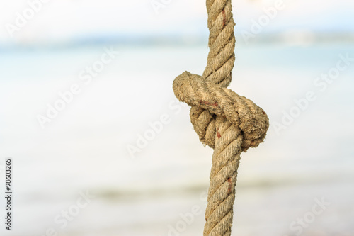 Old rope with tied knot on nature background