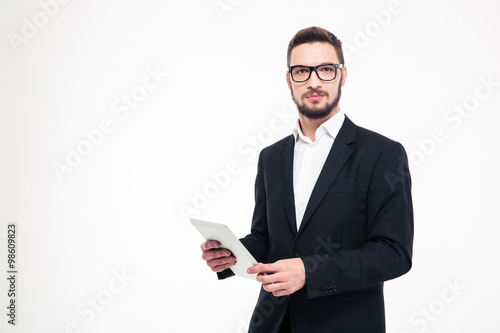 Serious businessman holding tablet computer