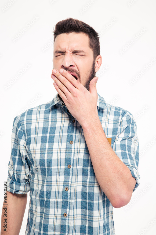 Tired exhausted bearded young man standing and yawning Tired exhausted bearded young man standing and yawning