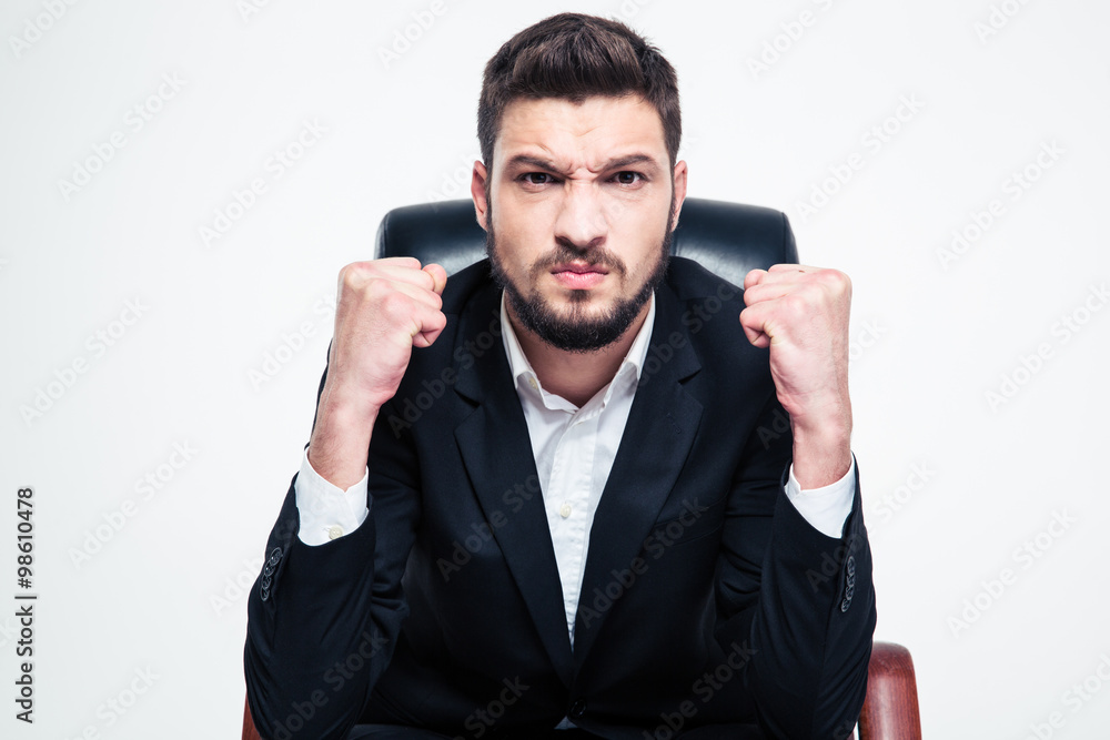 Angry annoyed bearded businessman sitting and showing fists Angry annoyed bearded businessman sitting and showing fists