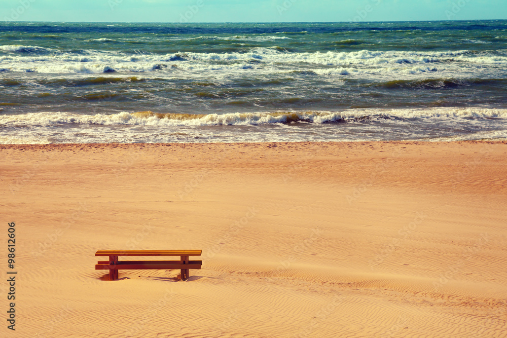 Stormy marine landscape, bench on the beach Stormy marine landscape, bench on the beach