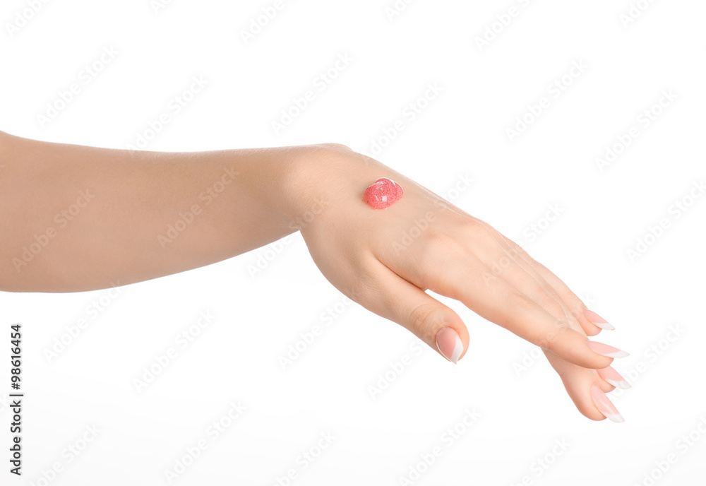 Health and body care theme: beautiful female hand with pink scrub cream on a white background isolated