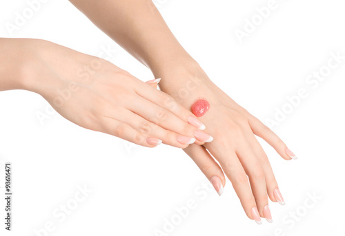 Health and body care theme  beautiful female hand with pink scrub cream on a white background isolated
