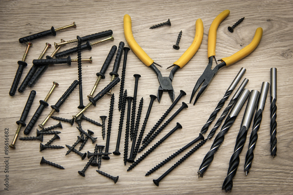 Different screws and drill bits on wooden background. Different screws and drill bits on wooden background.