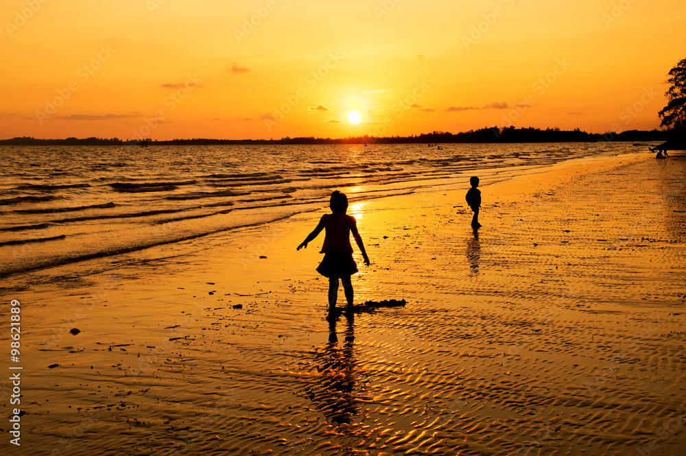 Silhouette of girl playing on the beach at sunset