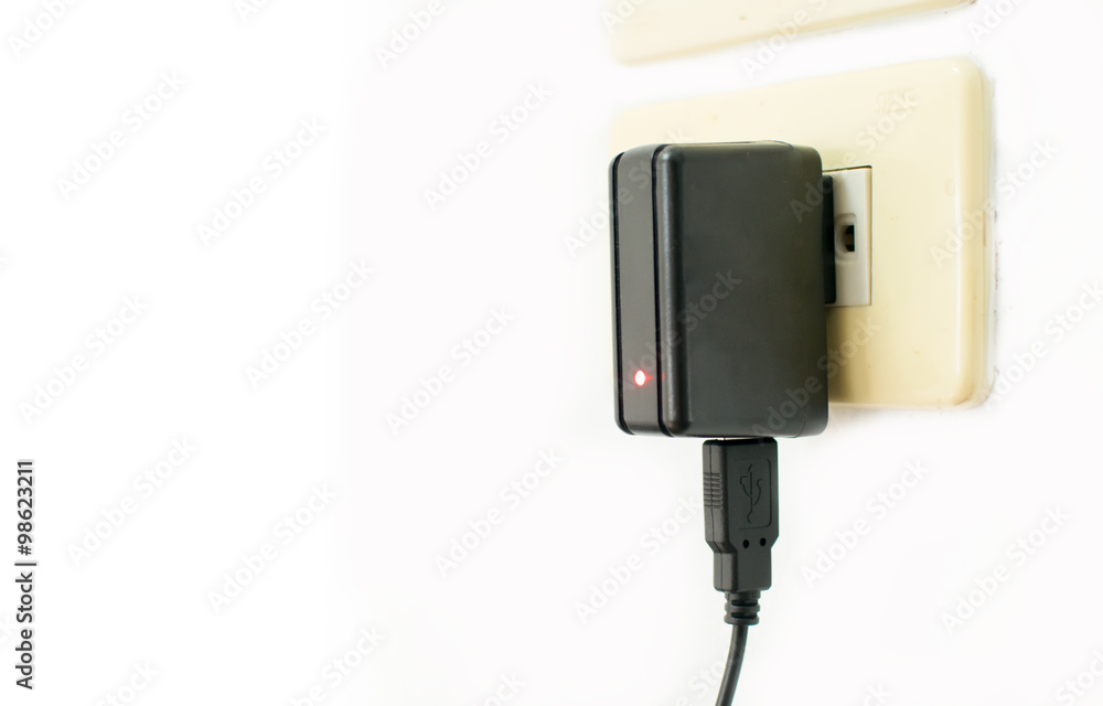 Mobile phone charger on electric outlet Mobile phone charger on electric outlet