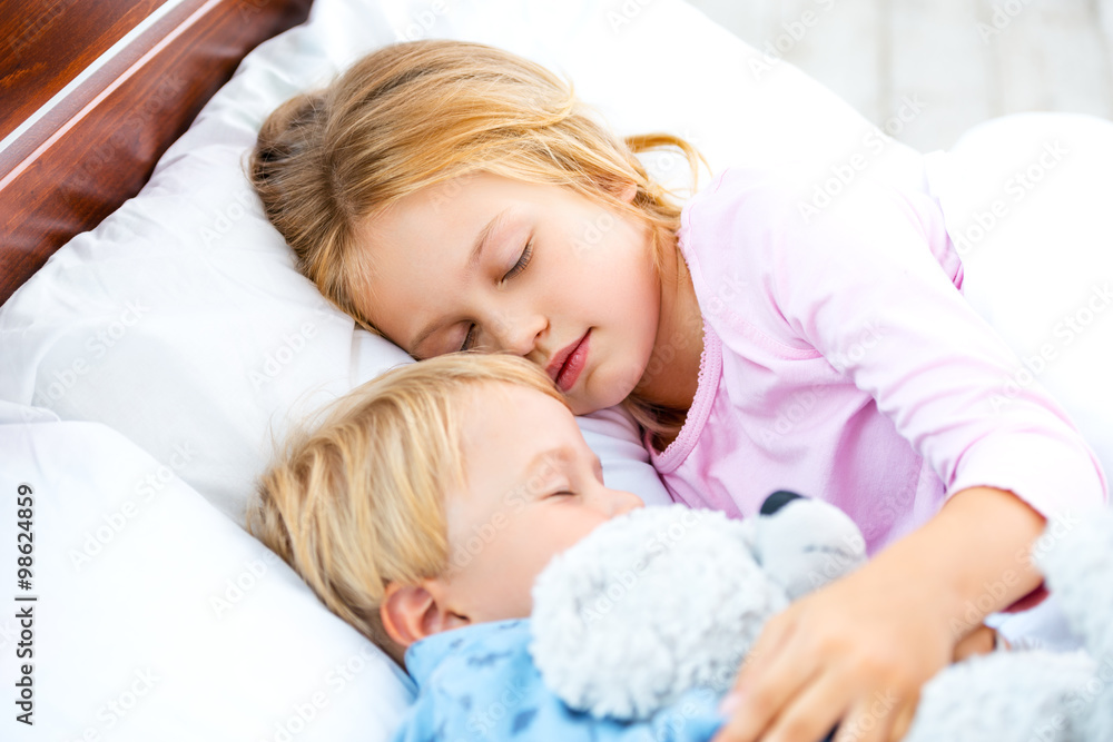Little girl and boy sleeping on white bed Little girl and boy sleeping on white bed