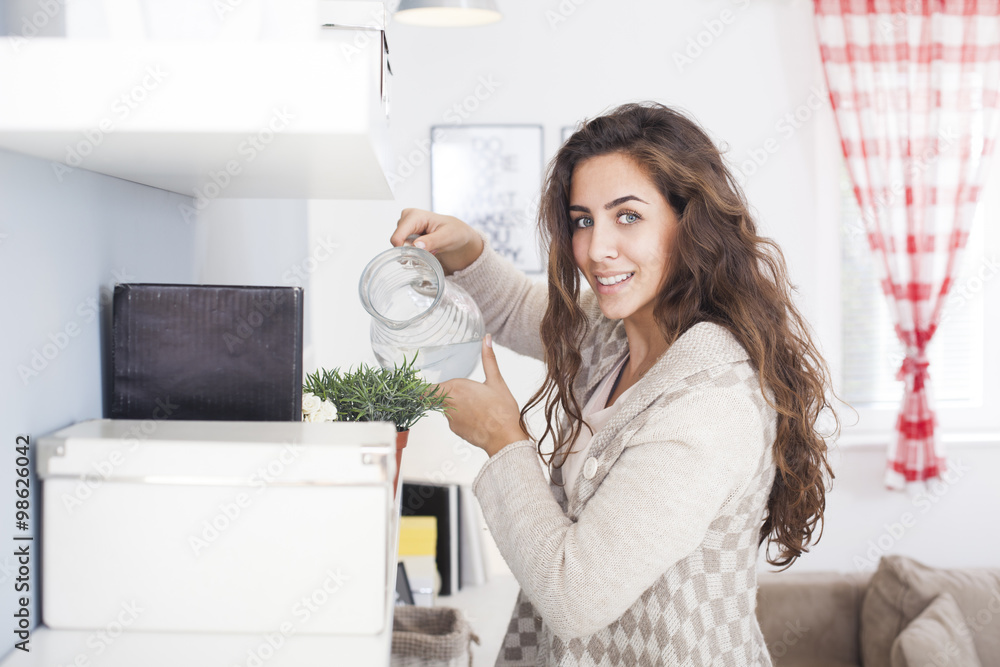 Beautiful woman arranging flowers and decorating her living room,shallow depth of field Beautiful woman arranging flowers and decorating her living room,shallow depth of field