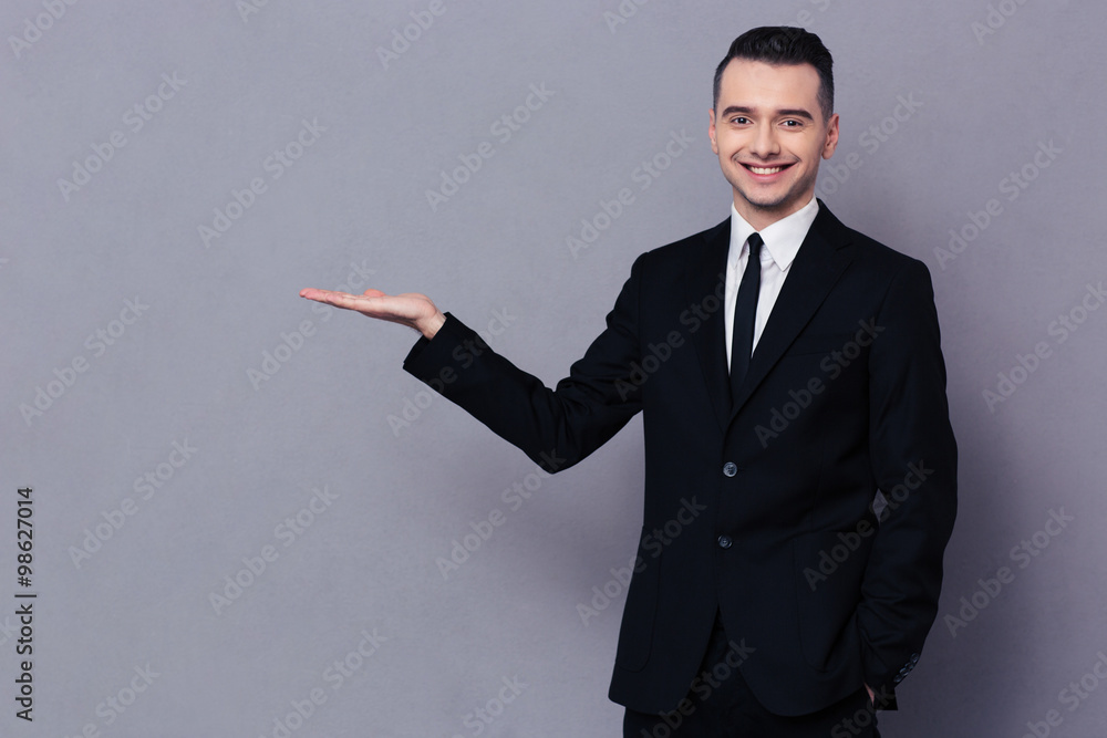 Smiling businessman holding copyspace on the palm Smiling businessman holding copyspace on the palm