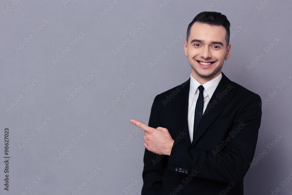 Smiling businessman showing finger away Smiling businessman showing finger away