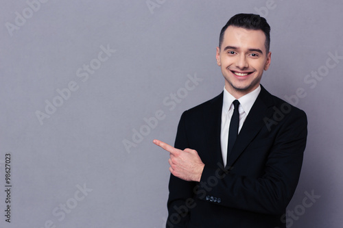 Smiling businessman showing finger away