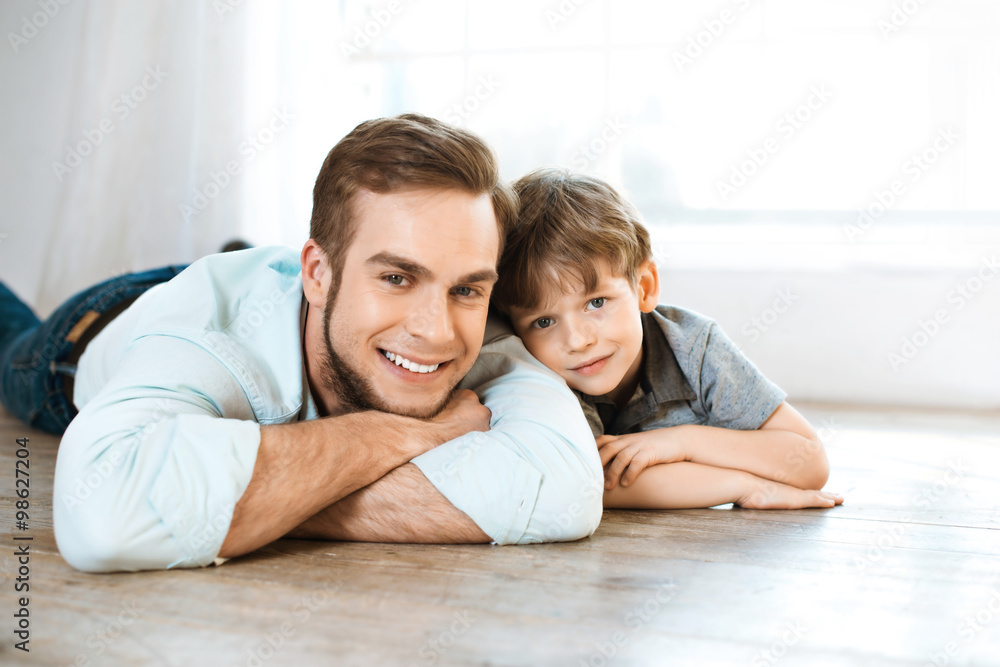 Little boy and his father on wooden floor