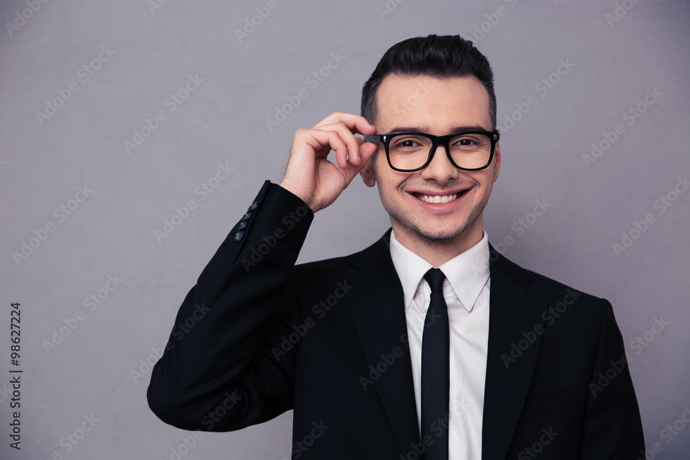 Smiling businessman in glasses looking at camera