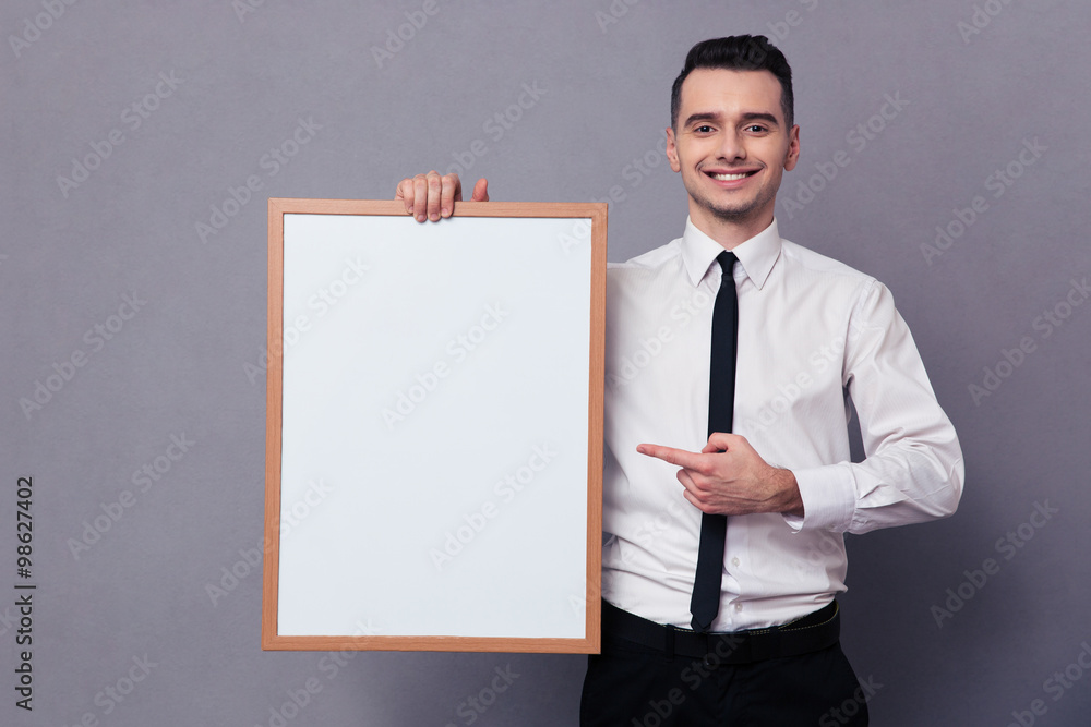 Smiling businessman holding blank board Smiling businessman holding blank board